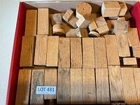 Box containing various unfinished wood blocks and shapes
