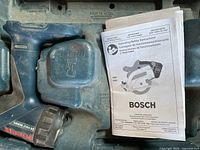 Interior of case showing drill handle, battery housing and manual