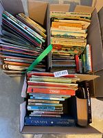 Three boxes filled with assorted children’s books showing spines and titles