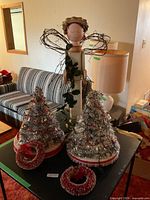 Full view of wooden angel, two tinsel trees, two mini wreaths