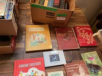 Overview of box of books and several titles laid out on table