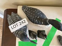 Two larger and two smaller carved wood loons