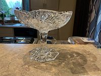 Side view of clear cut crystal pedestal bowl on countertop