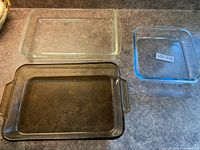 Three glass baking dishes of varying tint and size displayed on countertop