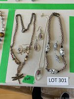 Three handmade necklace and earring sets on table