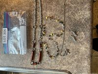 All four jewelry pieces laid out: wooden-bead chain necklace, beaded necklace, eagle pendant necklace, dangle earrings