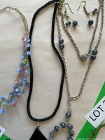 Overview of all jewelry pieces including three necklaces and pair of earrings.