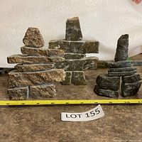 Front view of all three inukshuk sculptures with tape measure for scale