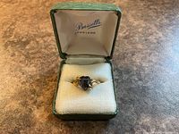 Ring in open Bassett Jewelers box, showing stone and band details