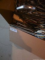 Open cardboard box showing large quantity of metal wire coat hangers