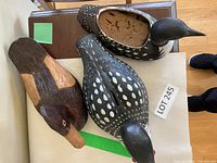 Top view of three carved bird decoys on table