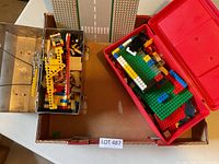 Open metal and plastic lunchboxes filled with mixed LEGO pieces