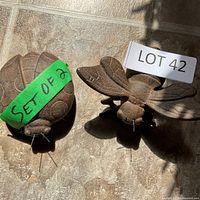 Top view of both cast metal insect figures showing overall shapes and surface detail