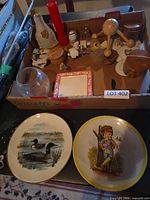 overview of box with assorted items and two decorative plates