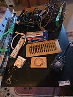 overview of table with power bar, cords, boxed air deflector, vent register, timers