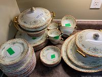 Group shot of entire dinnerware set showing stacks of plates, bowls, serving pieces