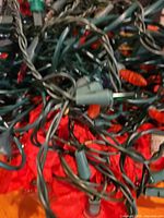 Tangled green-wire strings with various bulb covers visible