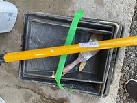 Stack of paint trays with extension pole and paintbrush visible