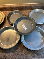 Five metal pie plates on counter