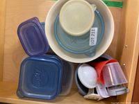 overhead view of stacked square containers, round bowls with lids, and measuring scoops