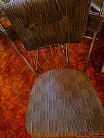 Close view of one chair showing chrome spindled back, brown striped seat and backrest