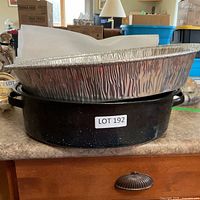 Black speckled enamel roasting pan with foil pan stacked on top, lid visible foreground