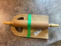Rolling pin placed atop cutting board, green tape present