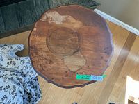 Top view of round plant stand showing scalloped edge and water damage