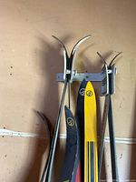 Skis pairs mounted on wall rack showing curved tips