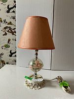 Full view of lamp showing shade, glass rose globe, base, cord