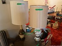 Two ceramic table lamps on side table with shades attached