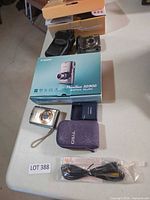 Lot overview showing both Canon cameras, cases, boxes, charger and cable