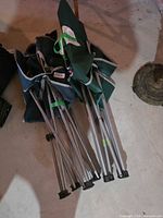 Folded green and navy camp chairs showing metal frames and canvas fabric