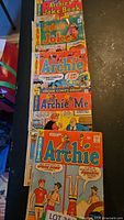Five vintage Archie series comic books laid out showing covers