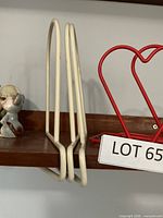 Off-white under-shelf bookend and red heart-shaped stand on shelf