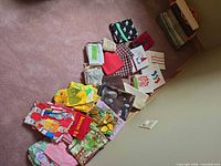 Entire assortment of aprons, tea towels, dish cloths and mitts spread on floor