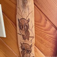 Full view of carved wood plank showing two owl designs