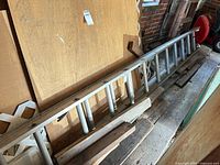 Full view of aluminum ladder leaning against wall