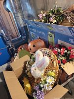 Lot overview showing two plastic pumpkin pails, boxes of floral wreaths and stems