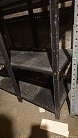 Black metal shelving showing perforated adjustable shelves and condition