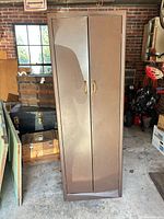 Front view of brown metal cabinet showing double doors and handles