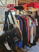 Rack showing bag, jackets, shirts, hats, fleece blankets