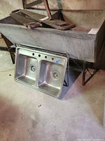 Front view of concrete trough on stand with stainless sink leaning in front