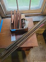Copper tubes, brass rods, solder spools in wooden box