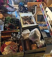 Overall view of tins and boxes holding ribbons, beads, plastic cutters, faux greenery, jars and tools