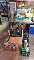 Lot overview showing hedge trimmer boxes, trimmer and shop vac hose