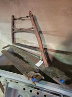 Crosscut two-man saw blades and bow frame saw on shelf