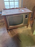 Front view of console CRT TV in wood cabinet.