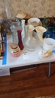 Wide view of assorted glass and ceramic vases, bowls and dish on table