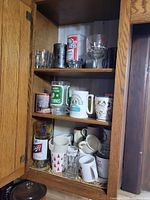 Cabinet shelves showing full assortment of mugs and glasses